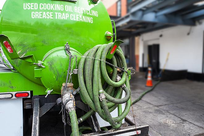 a grease trap being pumped by a sanitation technician in Lakeville